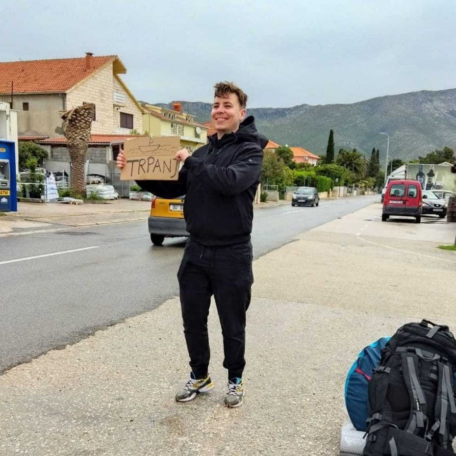 Młody mężczyzna łapiący stopa na granicy Chorwacji